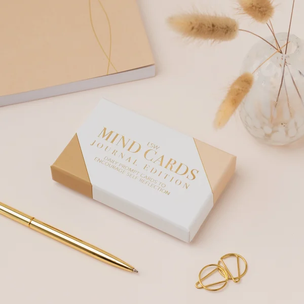 Mind Cards: Journal Edition box beside a gold pen and a notebook