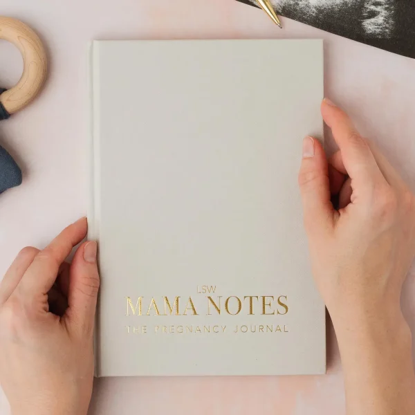 Hands holding the Mama Notes pregnancy journal